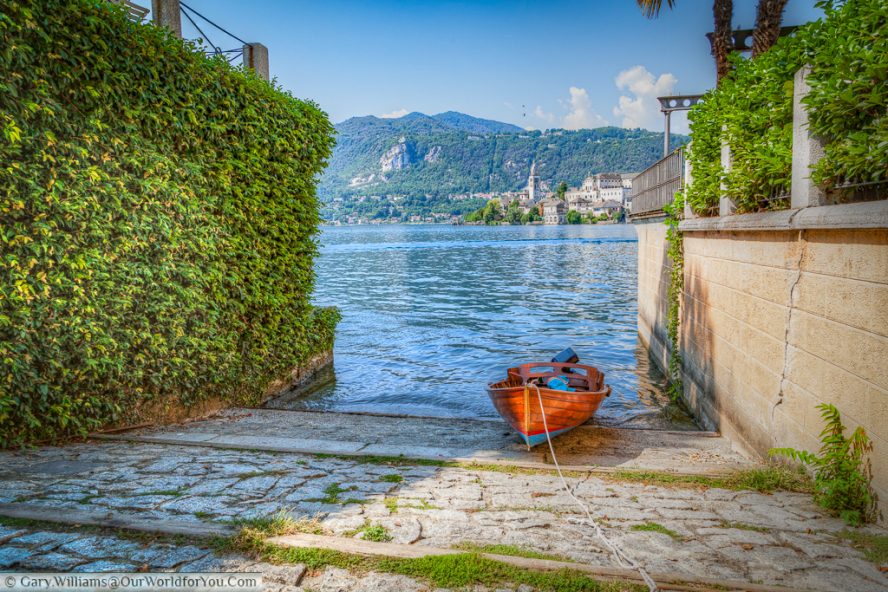 A boat moored up in Orta San Giulio , with Isola San Giulio in the background, Lake Orta, Italy