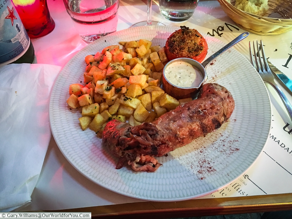 An Andouillette de Troyes served with sautee potatoes and a creamy garlic sauce