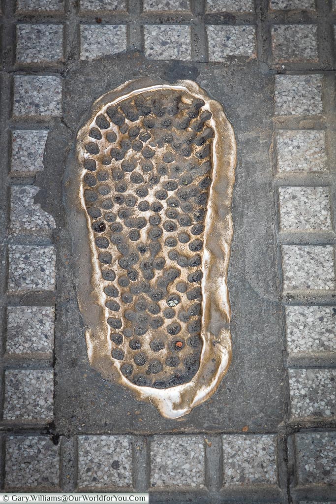 A brass insert of a footprint in the pavement in León, Spain.