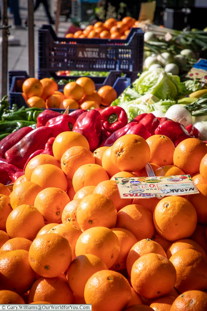 Vibrant oranges, and red peppers in a market in plaza mayor in Leon, Spain