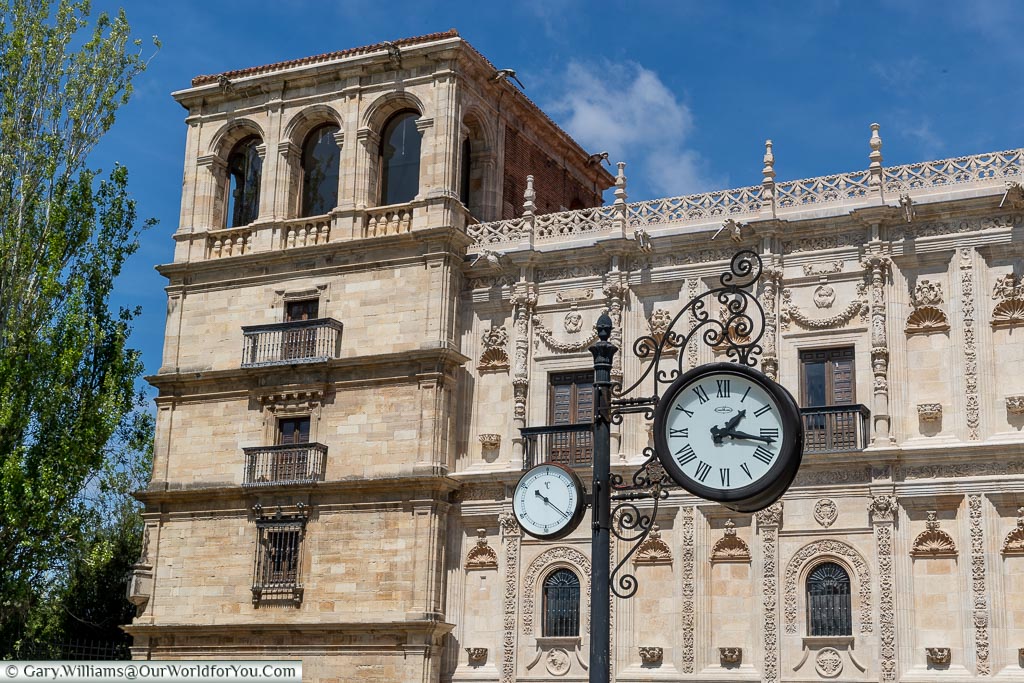 A clock & barometer attached to an iron post in front of the Convent of San Marcos in León, Spain