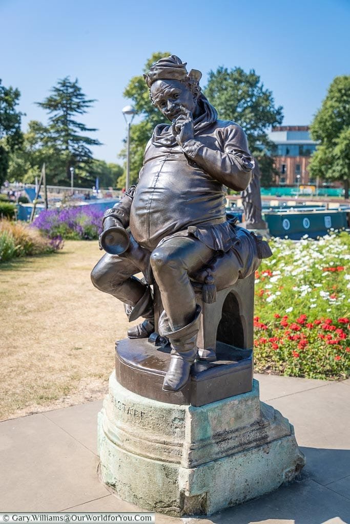 A bronze statue to Shakespeare's Flagstaff, seated with a tankard in hand, in the Bancroft Gardens in Stratford-upon-Avon