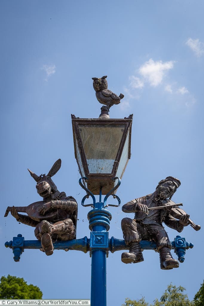 Three figures decorating a lampost in Stratford-upon-Avon.  Bottom from Shakespeare's 'A Midsummer night's Dream', Topol from Fiddler on the roof and the owl from 'The owl and the pussycat'