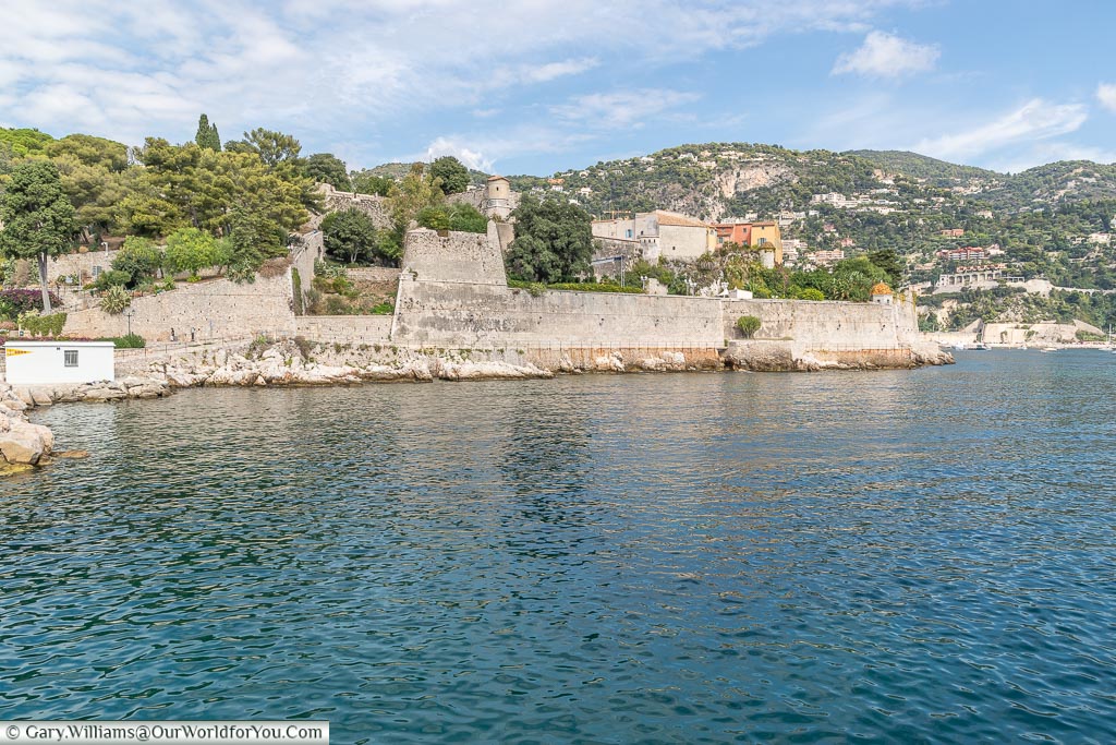 Looking across the water from La Darse harbour in Villefranche-sur-Mer to the Citadel with it high stone walls set into the coastline.