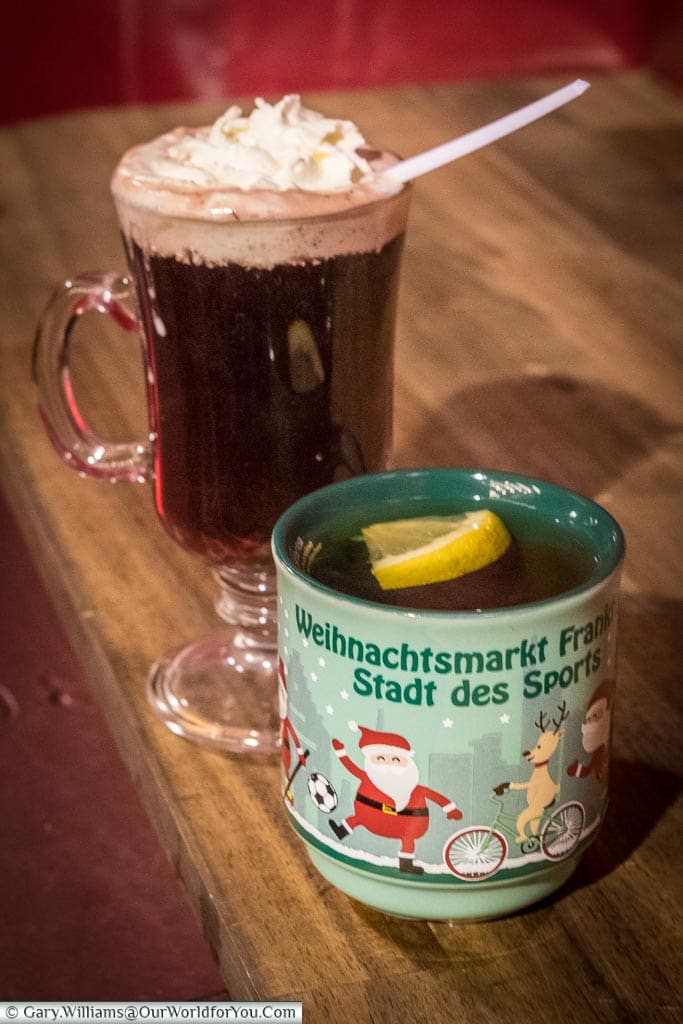 Two drinks from the Frankfurt's Christmas markets.  The first is a mug of Frankfurt's speciality apple gluhwein; the other is a glass Irish-Coffee style glass with a cherry gluhwein, topped with cream.