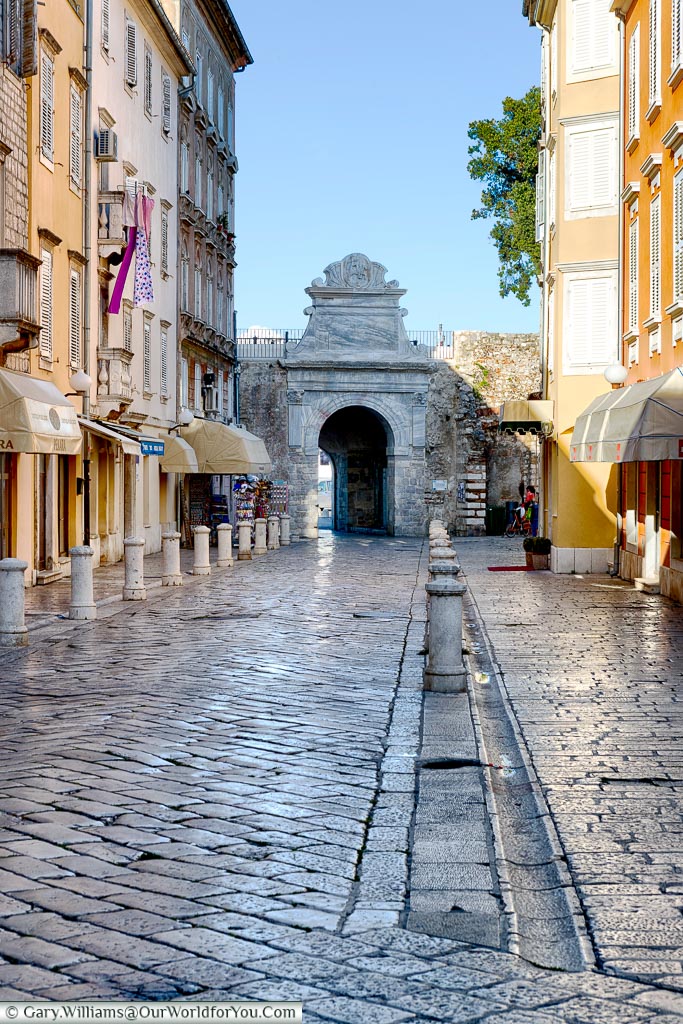 A cobbled lane between five-storey homes that leads towards Zadar's old  Sea Gate