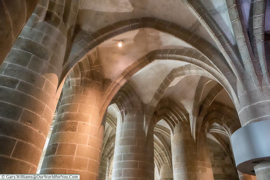 The colossal stone columns of the Great Pillared Crypt of Mont-Saint-Michel Abbey.