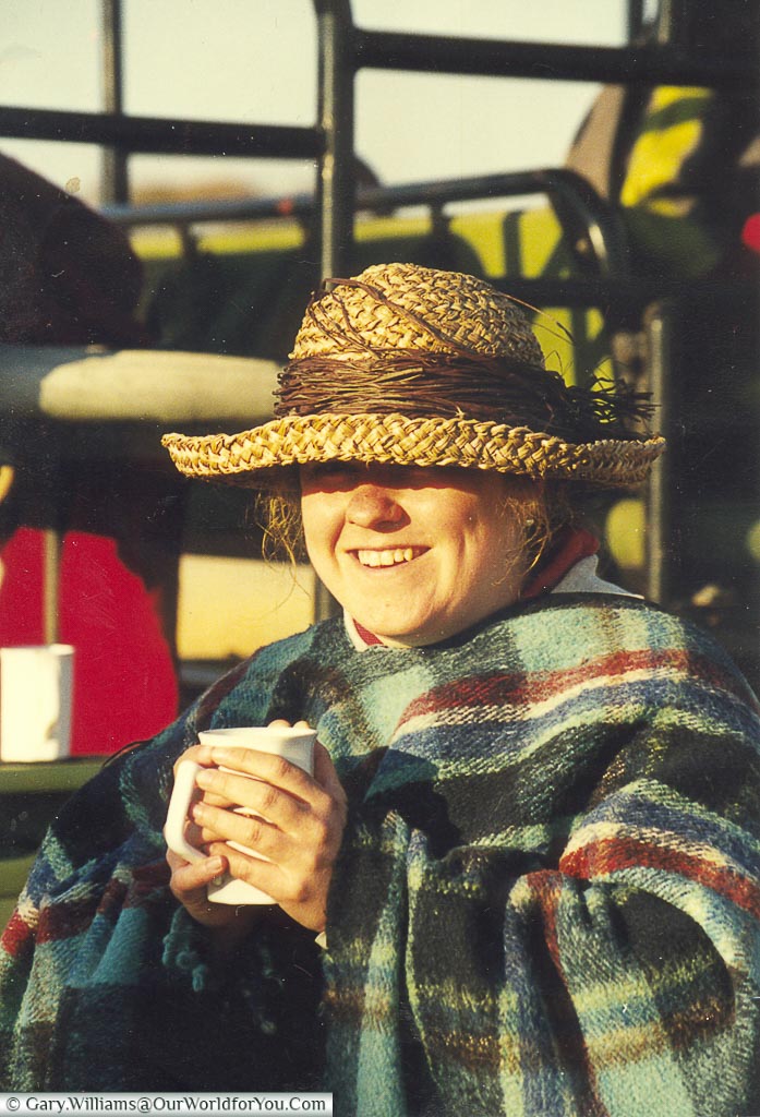 Janis wrapped in a warm shawl, cupping a hot cup of coffee on a morning safari in Zimbabwe