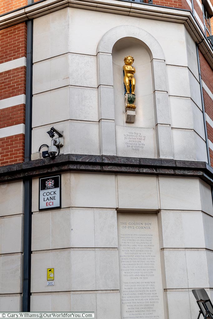 The 'Golden Boy of Pye Corner', above the sign for Cock Lane in the City of London