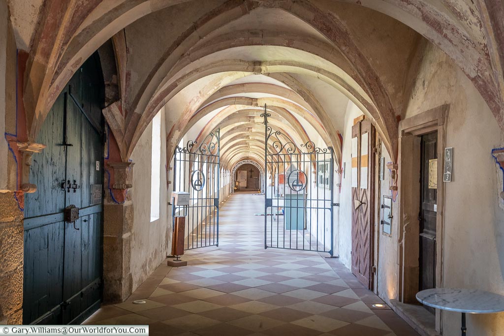 You are looking down the corridor of the cloisters within La Chartreuse monastery.