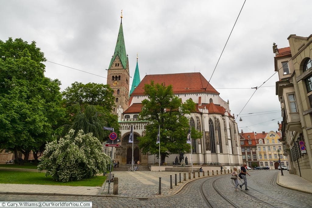 The exterior view of Augsburg Cathedral with its red-tiled roof and verdigris topped twin spires.