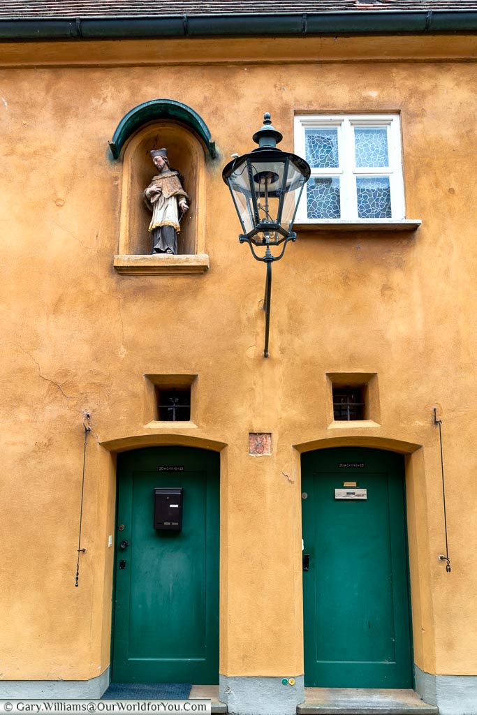 Two of the standard green doors on the ochre-coloured homes the Fuggerei.