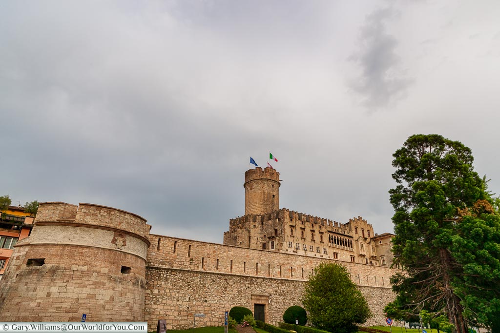 The Buonconsiglio Castle, and its surrounding walls, on an overcast evening.