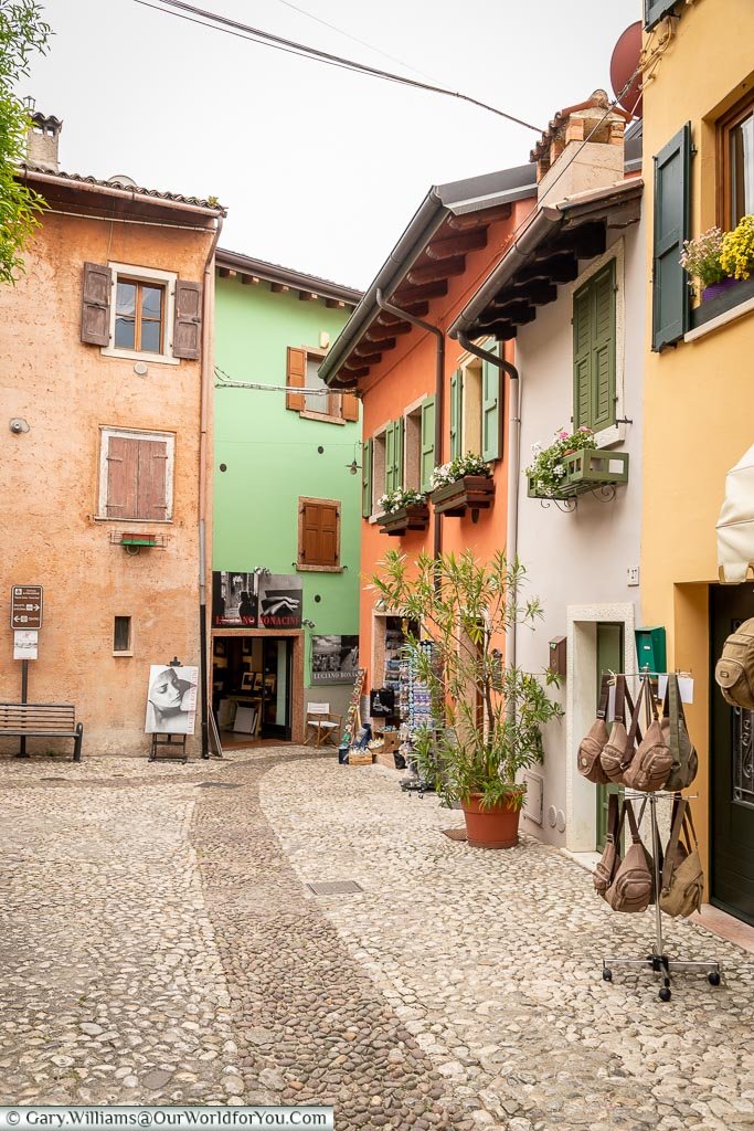 A cobbled lane with colorful homes and shops lining the path.