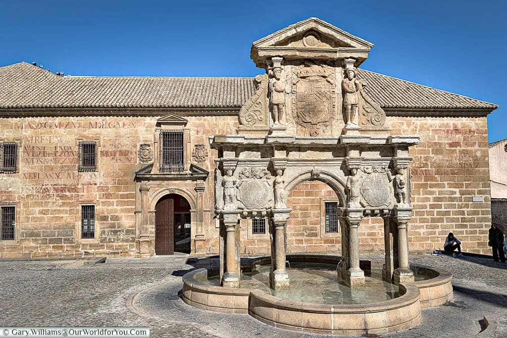 In front of a historic stone fountain in Baeza.