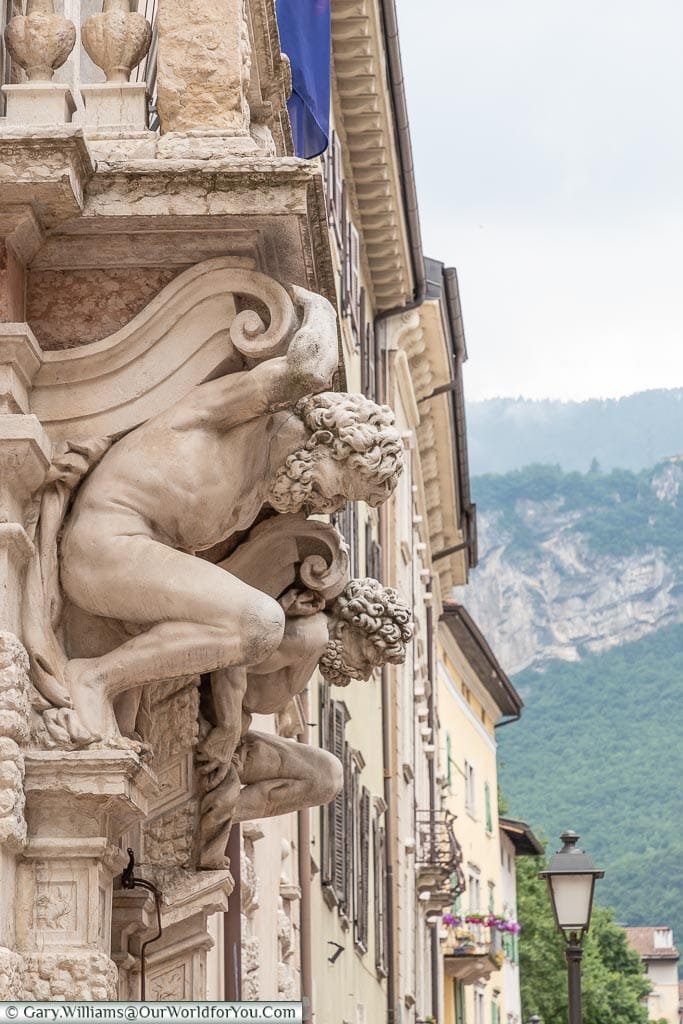 A closeup of the detail on the front of the building with two Grecian figures supporting the structure.