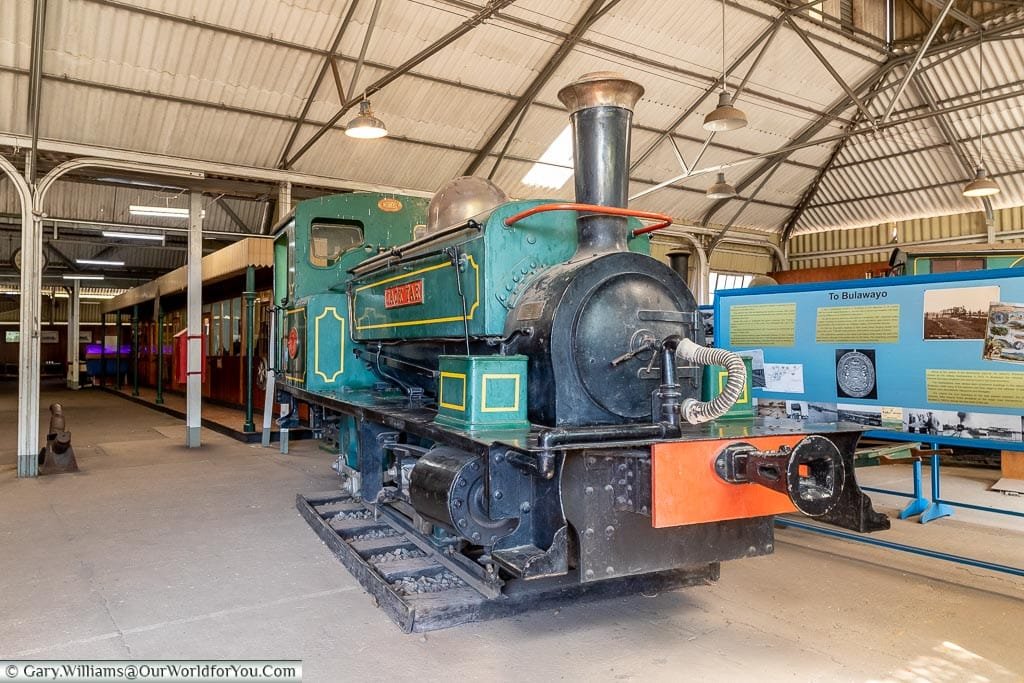 A restored small steam locomotive, predominately green with yellow trim, called the Jack Tar.