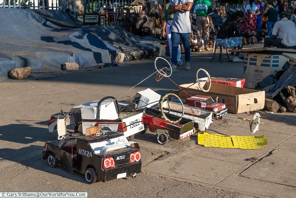 Children's toy cars made out of recycled materials on sale in a street market.