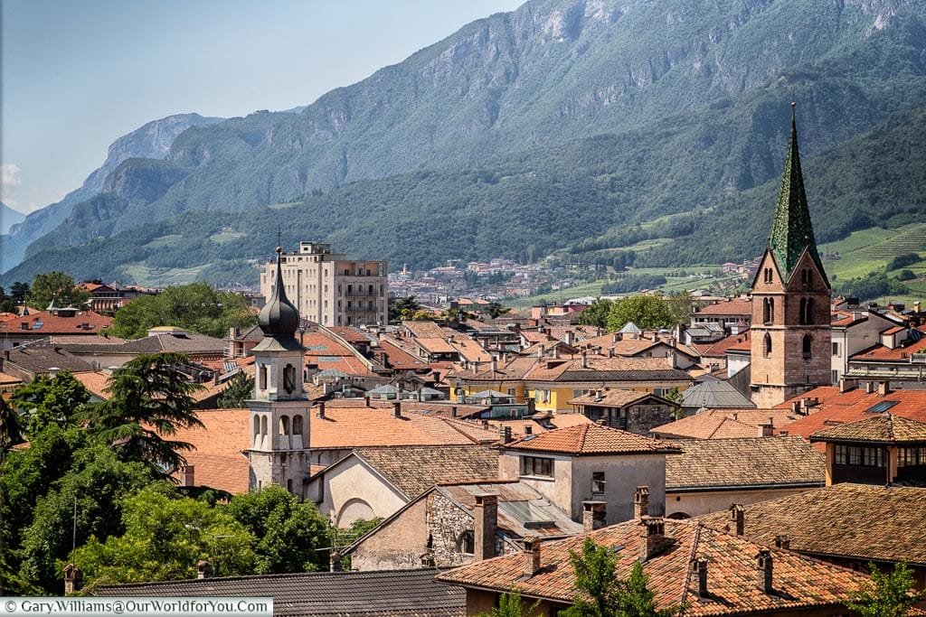 A view, from the castle, over the rooftops of the town with a church tower, and the mountains dominating.