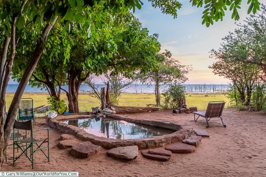 A small stone-lined pond at the camp at sunrise.