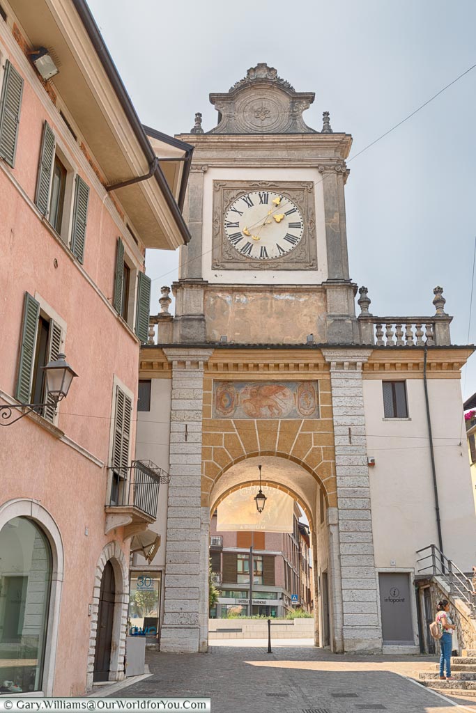 A clock tower with an arch at one end of the old town.