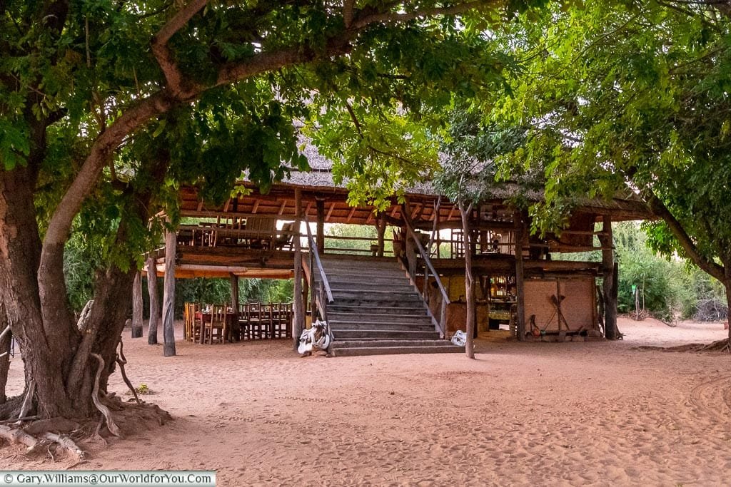 The two-storey boma, an open-air gathering place with a thatched room. The Boma is free standing in a small clearing in a wooded area.