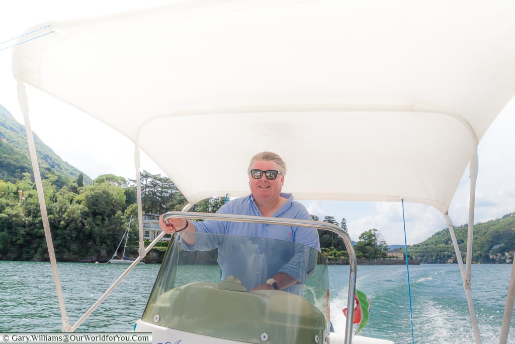 Gary at the controls of a powerboat on Lake Como