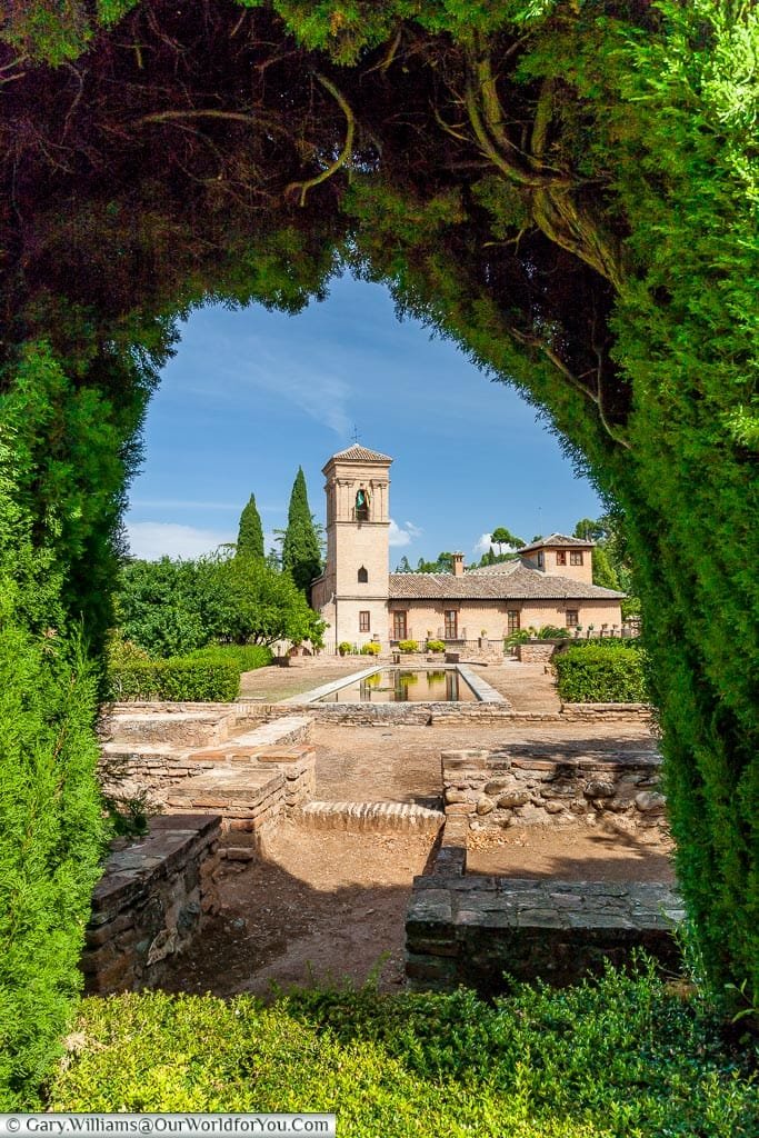 A view through a hedge to the Parador de Granada.