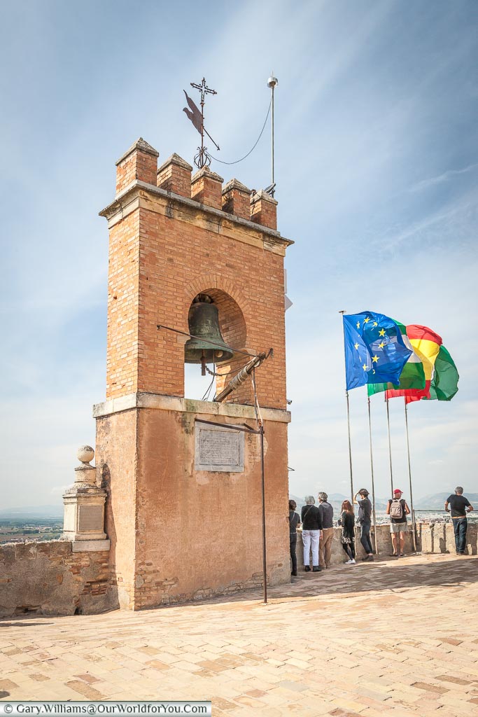 The bell tower at the top of the Alhambra palace with flags fluttering in the breeze.