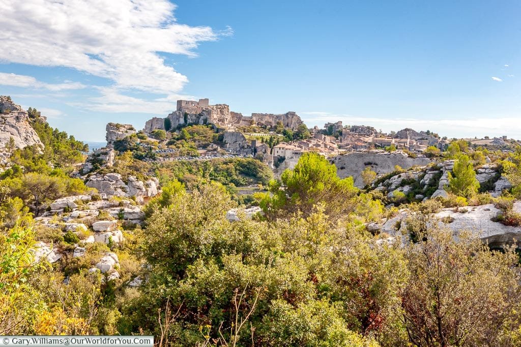 A view in the distance of the hillside town of Les Baux-de-Provence with the remains of its historic ruins atop the craggy rockfac