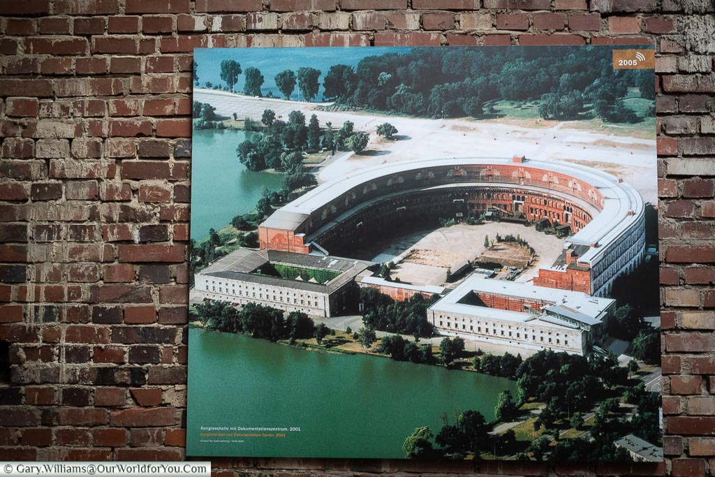 An aerial photo of the congress building from 2001 mounted on a wall inside the documentation centre.