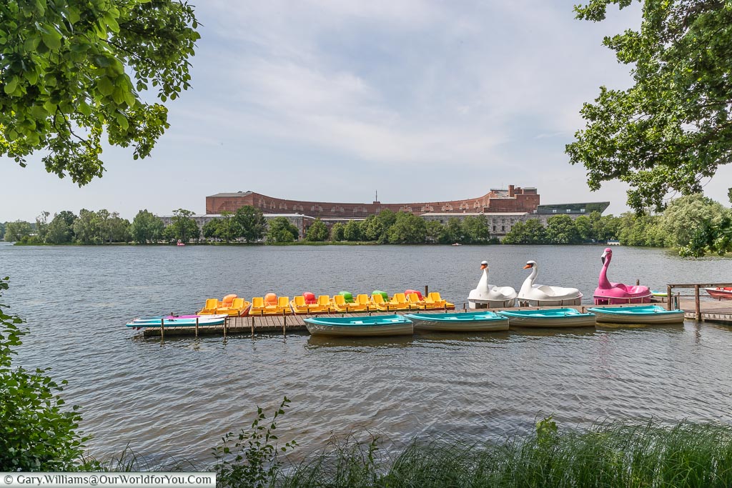 Brightly coloured pedalos on the Dutzendteich Lake with Nazi Party Congress Hall in the background.