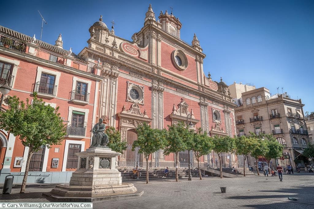 The red and white facade of the El Divino Salvador church from the Plaza del Salvador