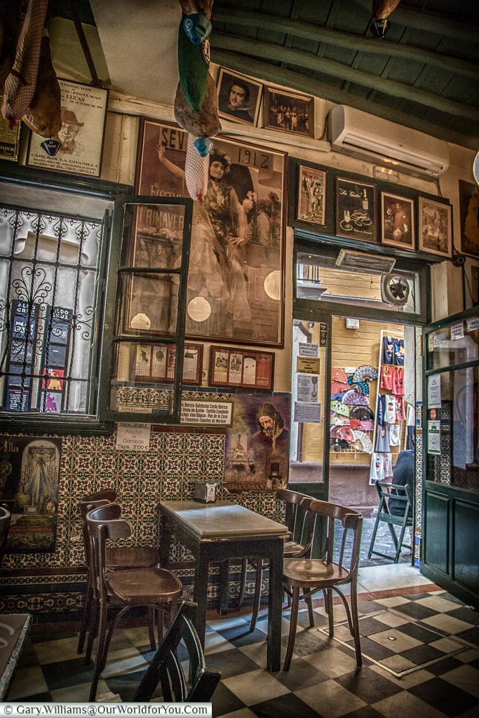 Inside the traditional Casa Placido with simple chairs & marble tabletops.  The walls are lined with framed pictures of flamenco artists & matadors.