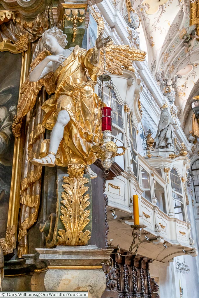 A close up of the detail inside Saint Emmeram’s Abbey focusing on an angel lavishly wrapped in a gold tunic with golden wings.