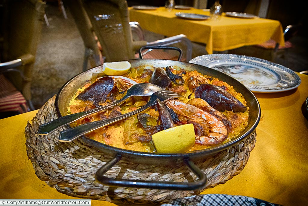 A large iron pan of saffron-coloured paella with mussels and giant prawns to share.