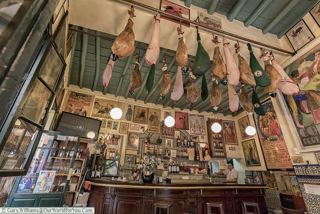 The counter of Casa Placido, a traditional bar with hams hanging from the roof.