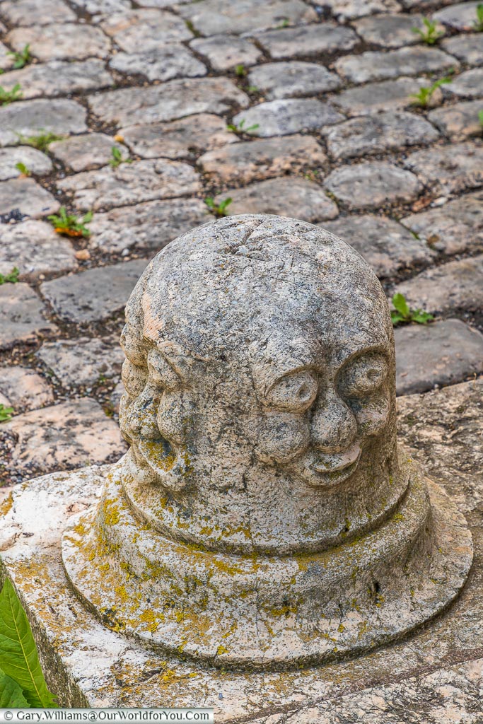 A face carved on a stone bollard.