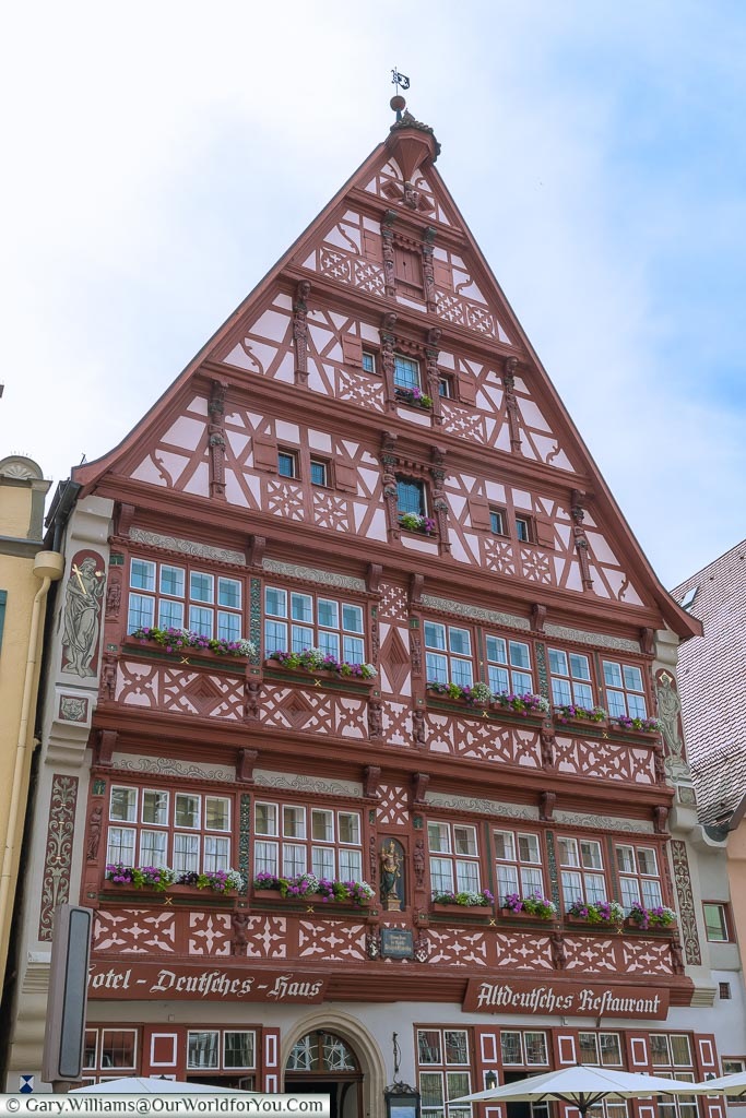 The ornate pink & red, half-timbered facade of the Hotel Deutsches Haus.  One of the many beautiful traditional buildings that make up Dinkelsbühl.