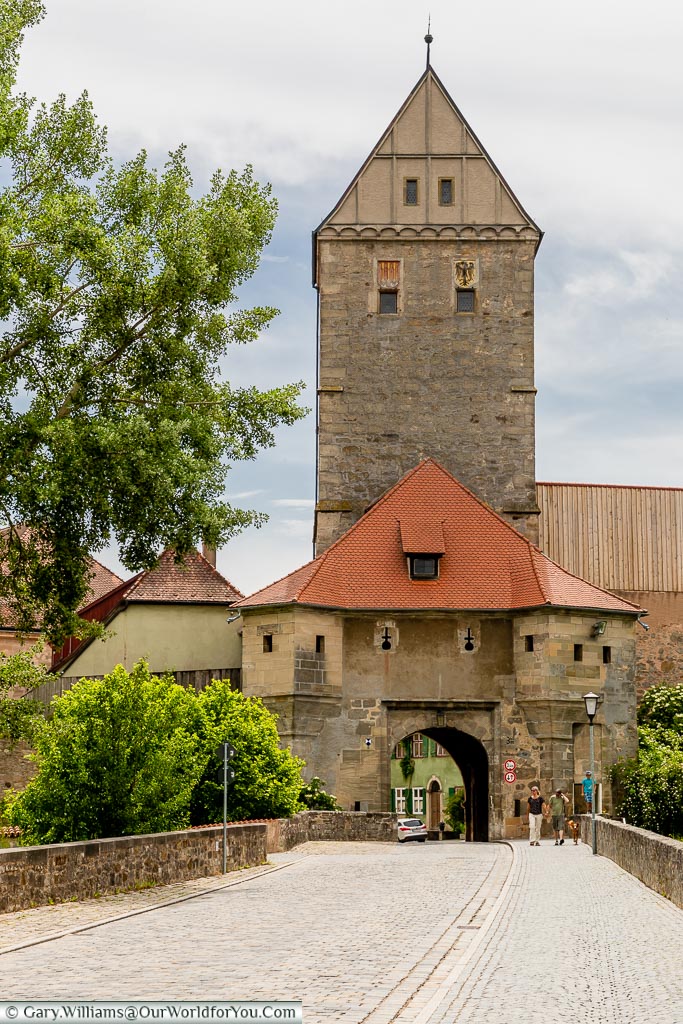 A cobbled lane leads into one of the cities gatehouses topped with the Rothenburger Tor.