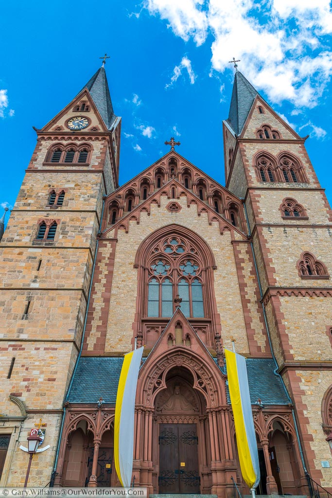 Looking up at the front of the Cathedral of Bergstraße with its yellow brickwork and deep red stonework.