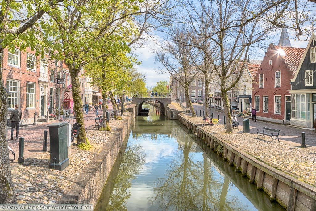 The tree lined canal running through central Eden in the Netherlands with cobbled lanes on either side.