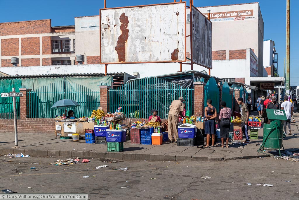 A bustling street corner in Bulawayo where a few stalls have been set up on plastic creates selling fruit and vegetables.