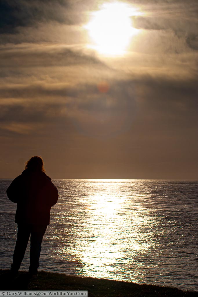 A silhouette of Janis wrapped up warmly on a winter's day overlooking English Channel from Ventnor on the Isle of Wight