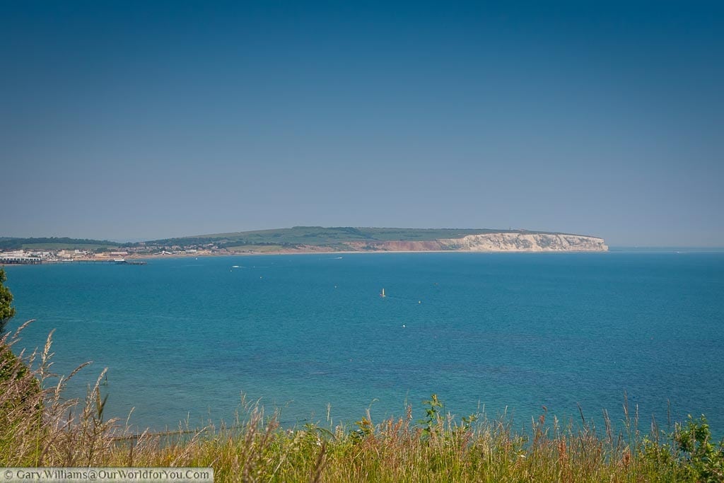 The azure blue waters of Sandown bay and the chalky outcrop of Culver Down on the Isle of Wight in the south of England.