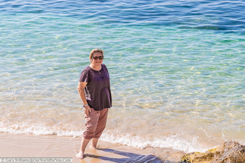 Janis with her toes in the Mediterranean sea as it laps up to the beach in Villefranche-sur-Mer.