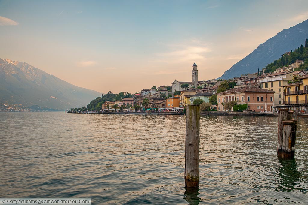 Looking back from the very north of Limone Sul Garda to the town and the restaurants that line the lakeside with the church tower dominating the skyline as dusk sets in.