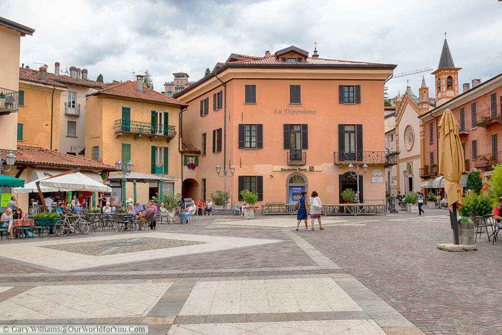 One of Menaggio pretty Little squares, lined with restaurants, where all the buildings are painted different shades of ochre.