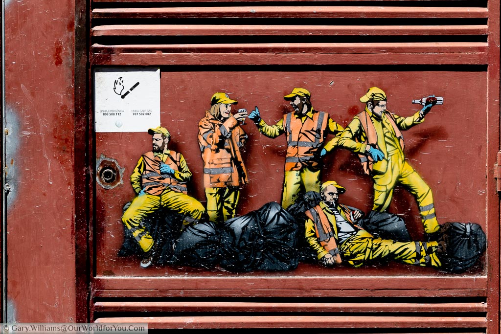 A piece of street art depicting a group of binmen drinking and relaxing amongst the refuge sacks in Porto.