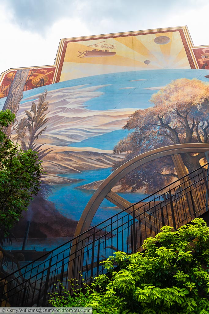 The mural covering one edge of the Jules Verne House that depicts scenes from Around the world in 80 days.